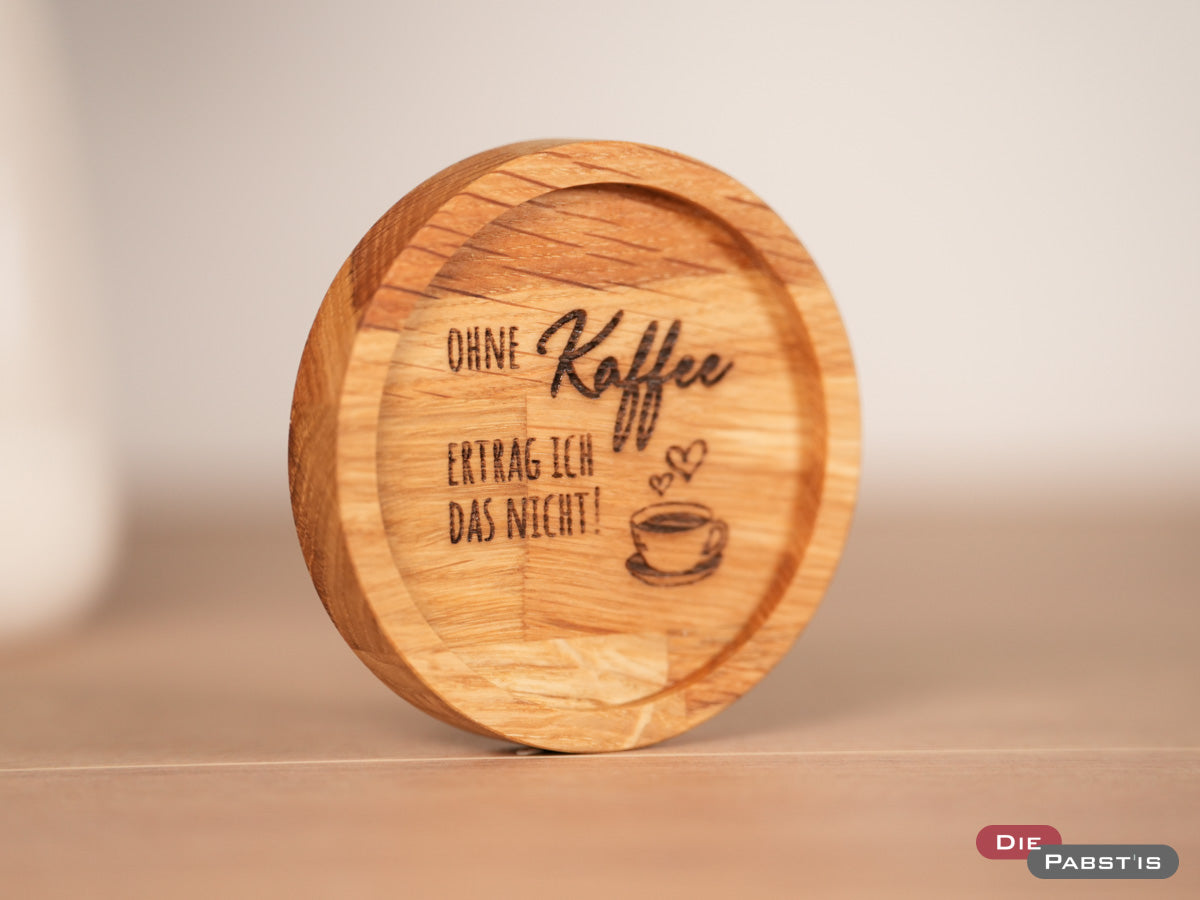 Untersetzer aus Eichenholz mit Gravur ‚Ohne Kaffee ertrag ich das nicht‘ – perfekt für echte Kaffee-Liebhaber.